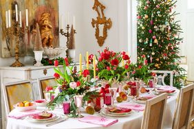 Colorful table setting with floral centerpieces and Christmas tree in back