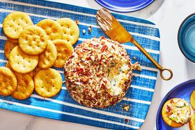 bacon ranch cheese ball on a serving platter with crackers and a knife - Southern Living