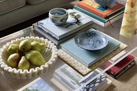 acrylic coffee table with styled stacked coffee table books