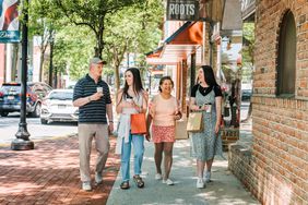 Four people walk on a street in downtown Dover, Delaware.