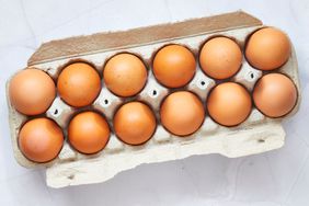 a dozen brown eggs in a cardboard carton