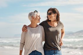 Mother and Daughter Walking On Beach