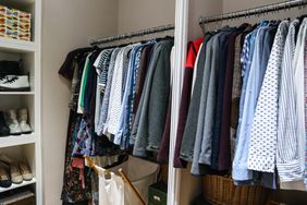 Clothes in closet hanging on racks with shelves