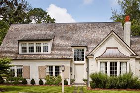 Converted farmhouse with shingled roof features a neutral color palette. Farrow and Ball's Stony Brick was used for the door, and archived color, Clunch, for the brick.