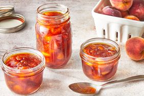 peach jam in jars with fresh peaches nearby