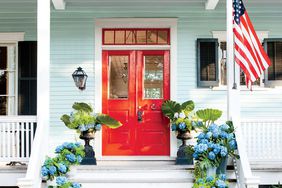 Brilliant Red Front Door on a Light Blue House with Containers of Hydrangeas