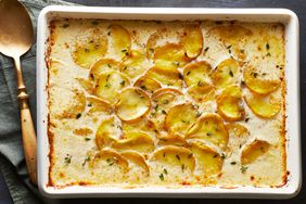 Scalloped Potatoes And Ham in a white baking dish - Southern Living