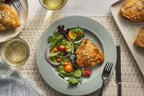 Southern Living Crispy Chicken Thighs on a plate with a salad on the side